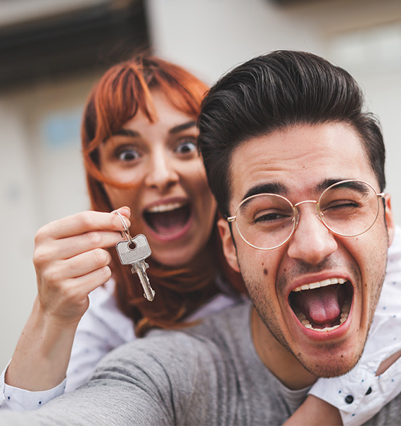 couple holding key to new home